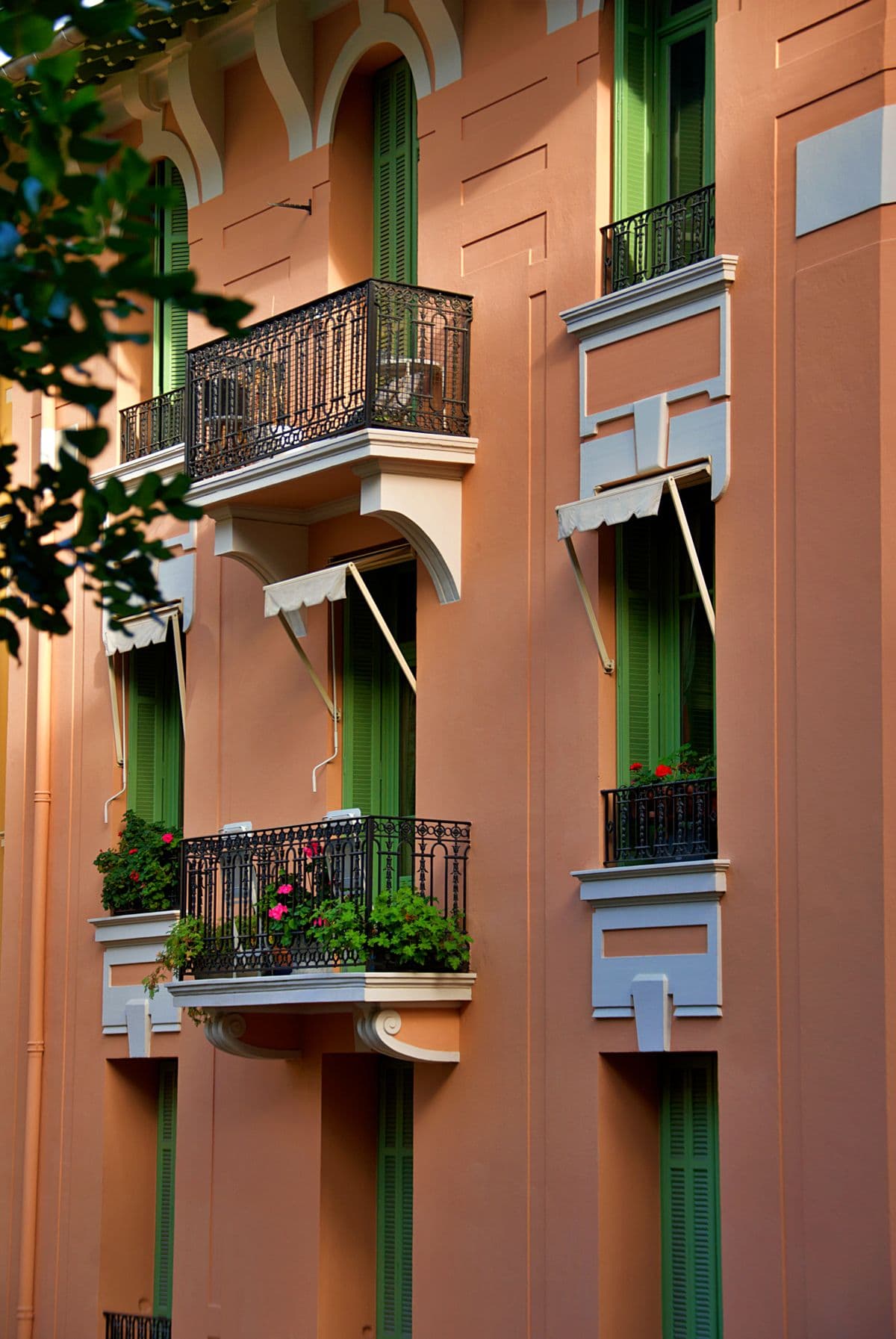 Fachada mediterránea en terracota con balcones de hierro